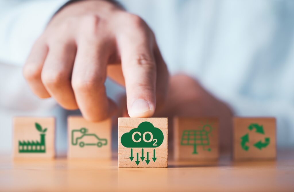 Une main pointant un cube portant une icône Co2