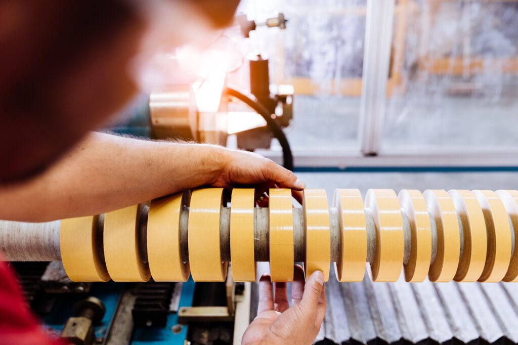 Image zoomée sur une machine avec des rouleaux d'adhésifs découpés