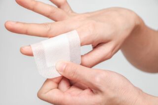 Image d'une personne enroulant un pansement autour d'un de son index